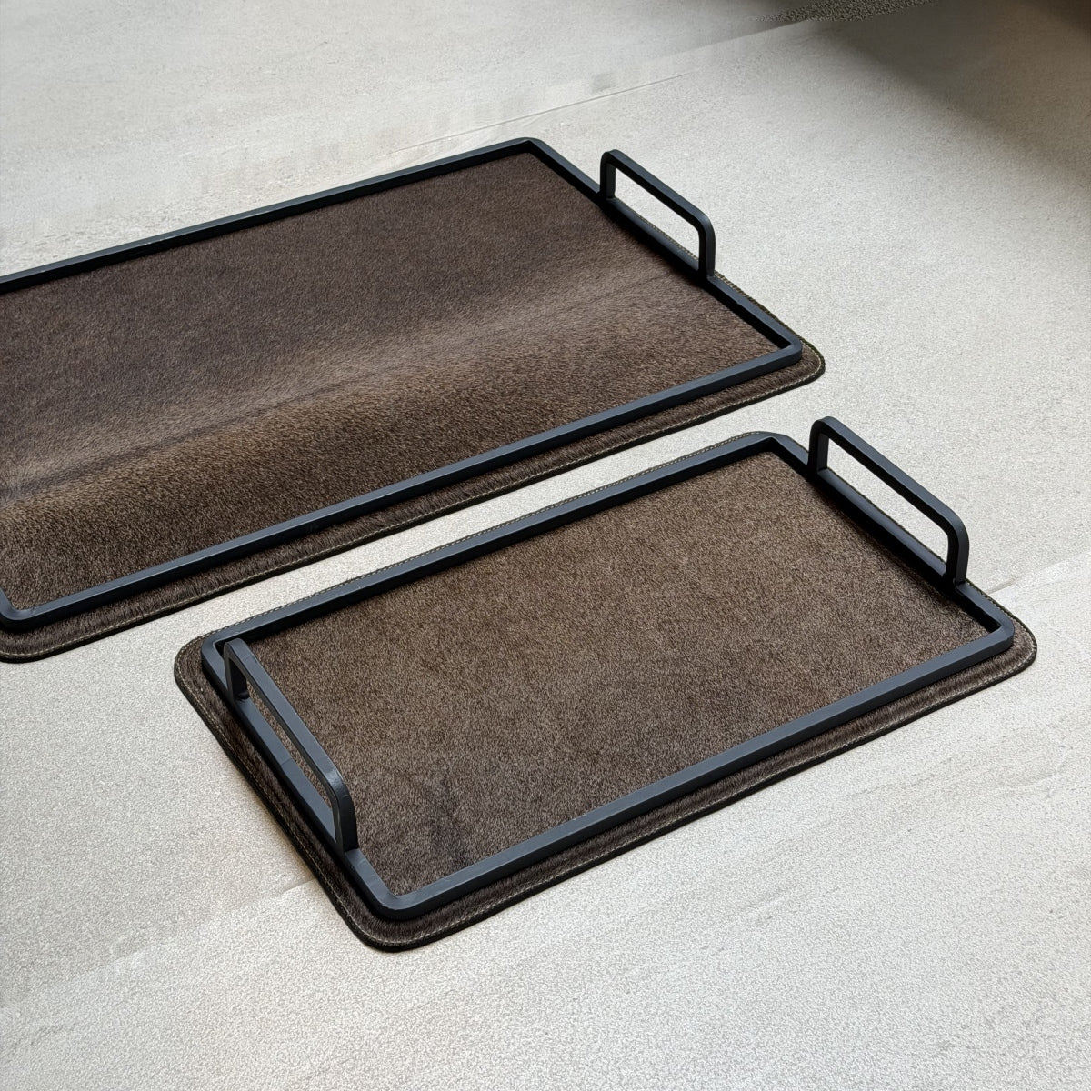Set de charolas cowhide - 311, vista cerca. Piel natural café y herrería negra.