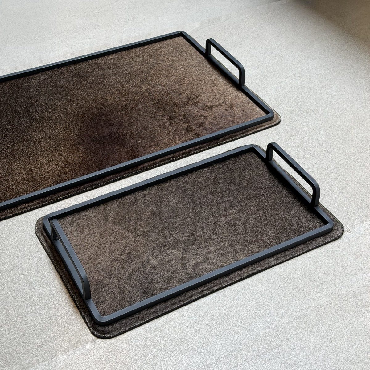 Set de charolas cowhide - 299, vista cerca 2. Piel natural café y herrería negra.