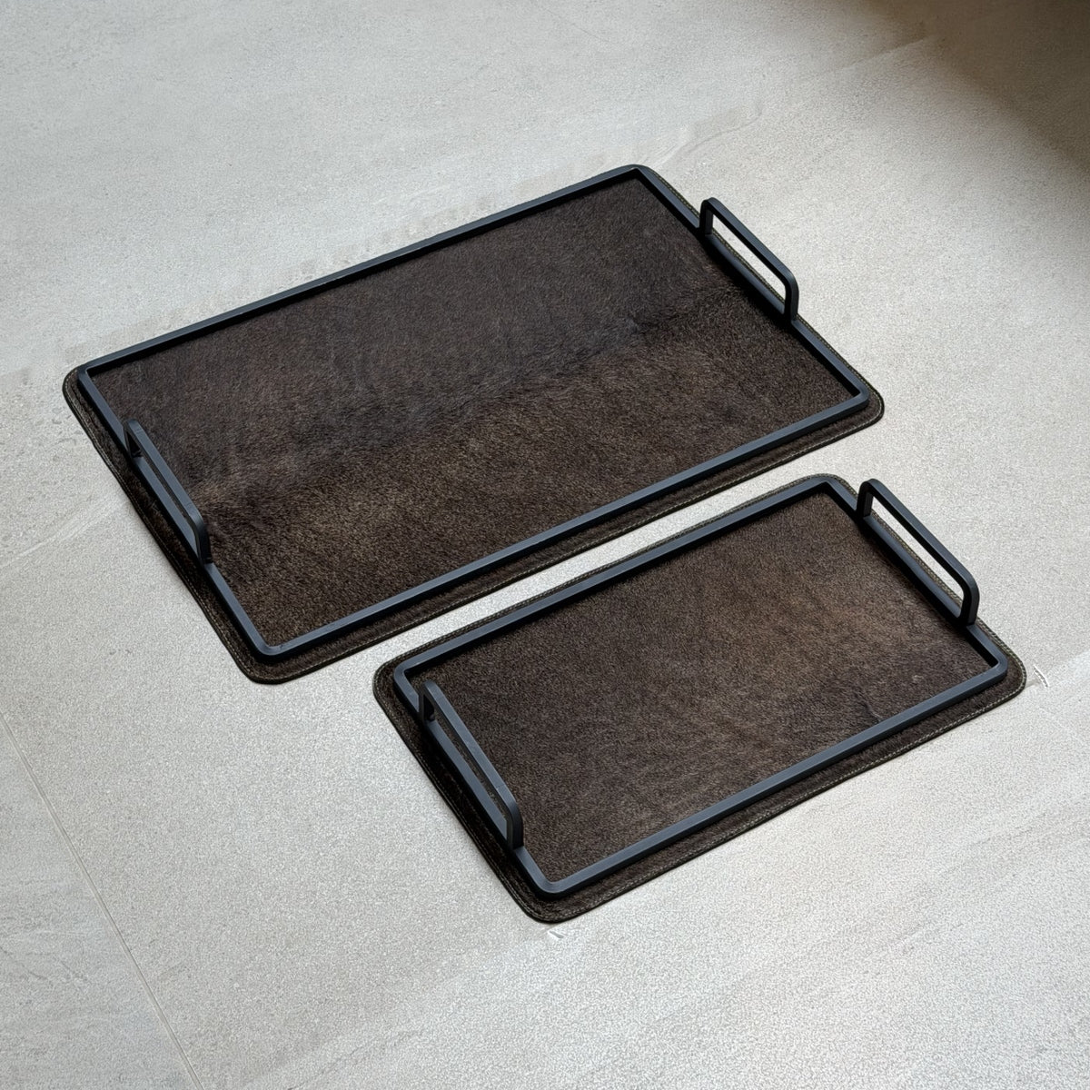 Set de charolas cowhide - 301, vista lejos 3. Piel natural café oscuro y herrería negra.