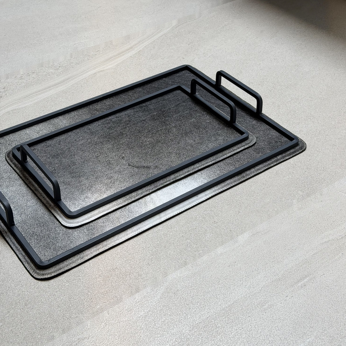 Set de charolas cowhide - 302, vista cerca. Piel natural gris oscuro y herrería negra.