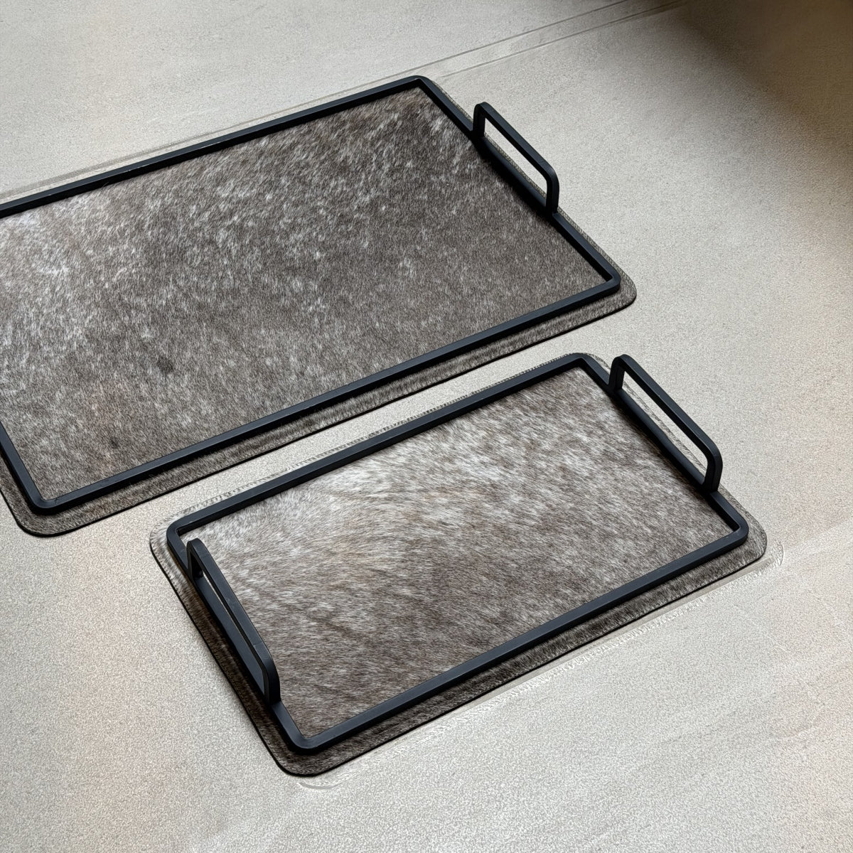 Set de charolas cowhide - 306, vista cerca 3. Piel natural gris jaspeado y herrería negra.