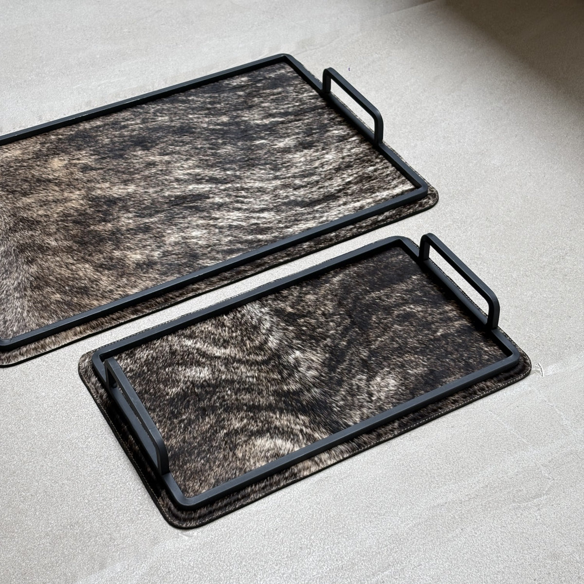 Set de charolas cowhide - 308, vista cerca 2. Piel natural café atigrado y herrería negra.