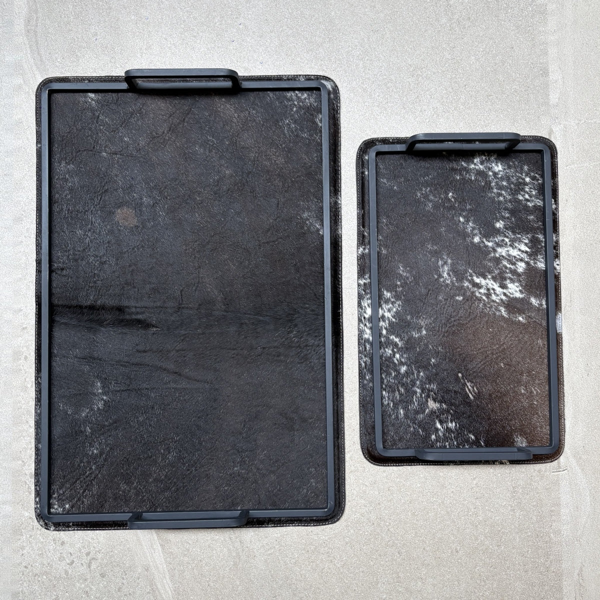 Set de charolas cowhide - 310, vista superior 2. Piel natural negro y café con blanco y herrería negra.