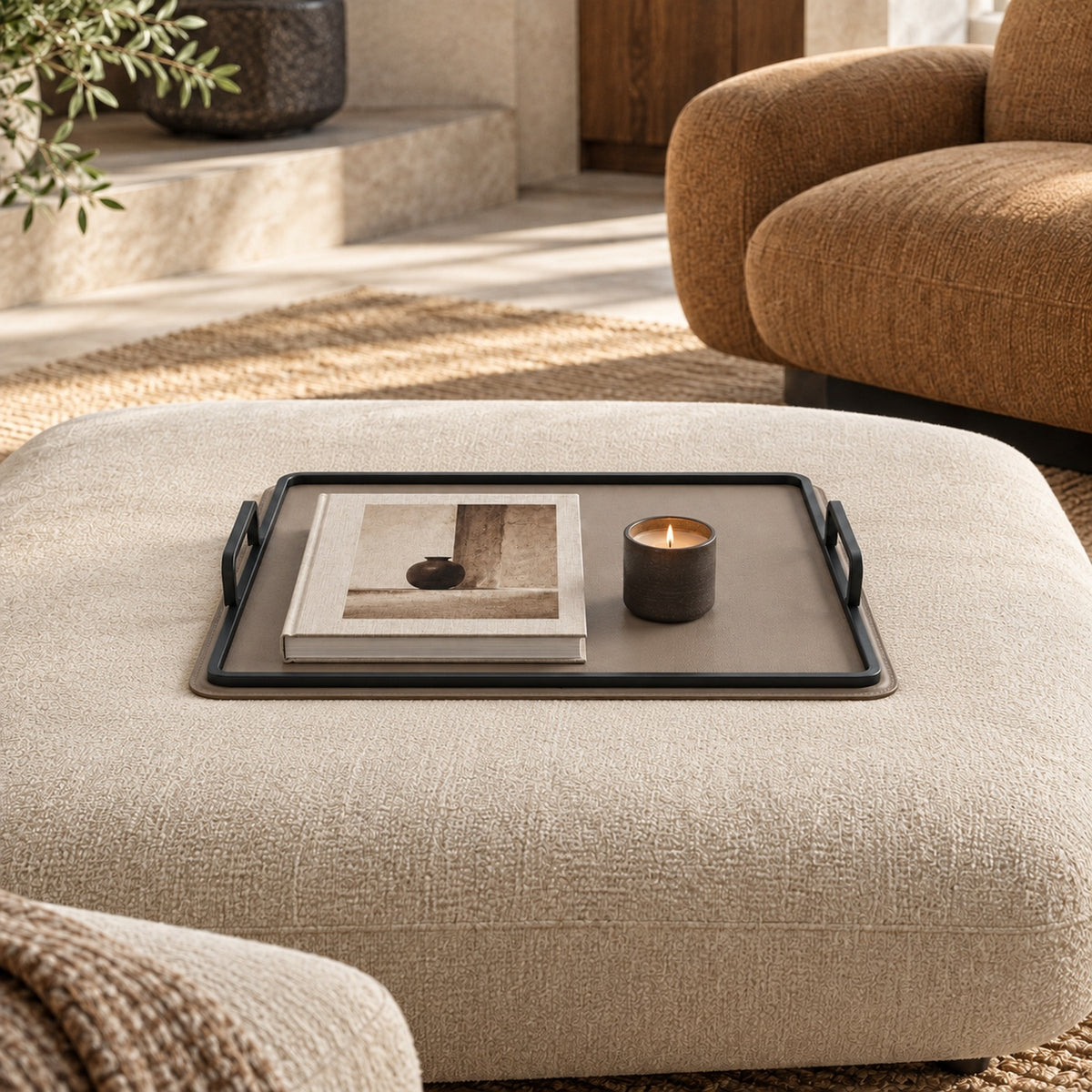 Charola beige grande sobre ottoman con libro y vela