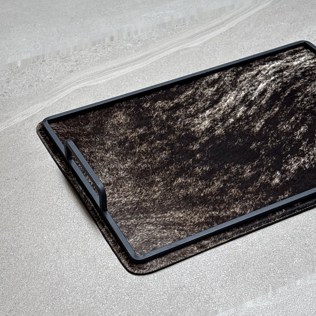 Charola cowhide grande - 323, vista cerca. Piel natural café y negro jaspeado y herrería negra.