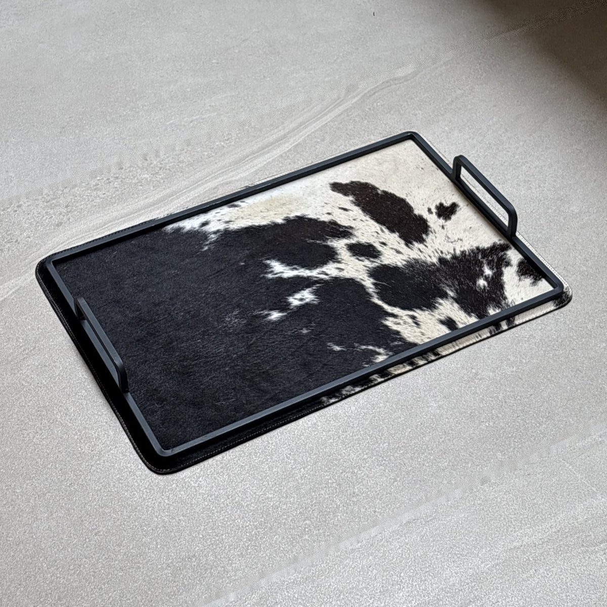 Charola cowhide grande - 327, vista lejos. Piel natural con pelo y herrería negra.