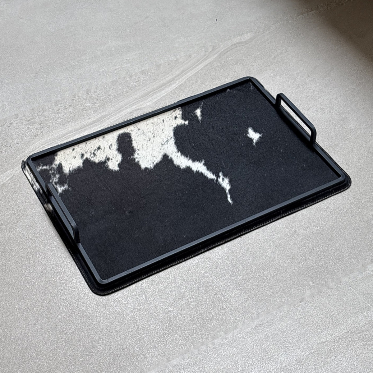 Charola cowhide grande - 328, vista lejos. Piel natural con pelo y herrería negra.
