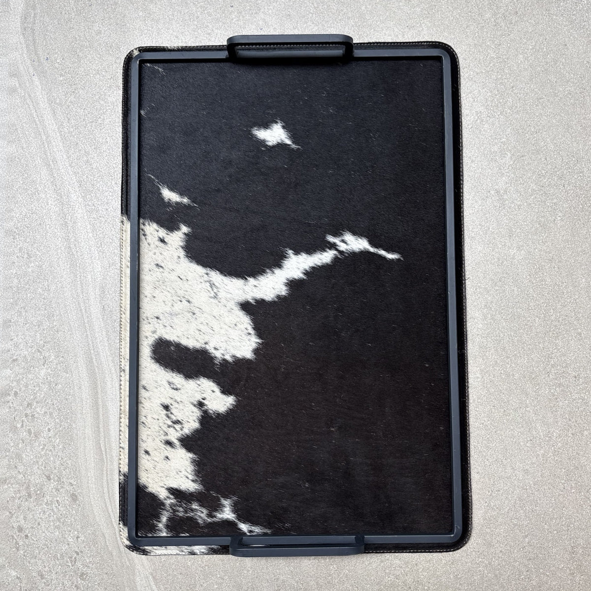 Charola cowhide grande - 328, vista superior. Piel natural con pelo y herrería negra.