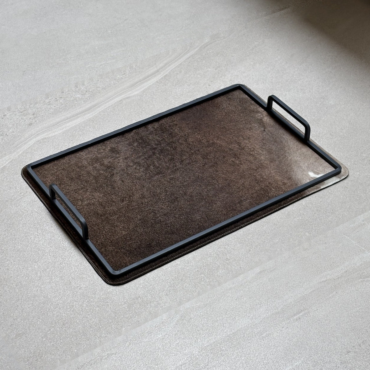 Charola cowhide grande - 333, vista lejos. Piel natural con pelo y herrería negra.
