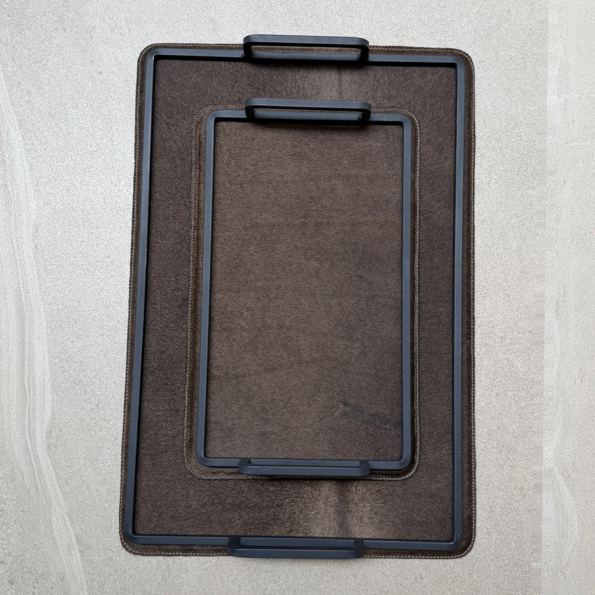 Set de charolas cowhide - 311, vista superior. Piel natural café y herrería negra.