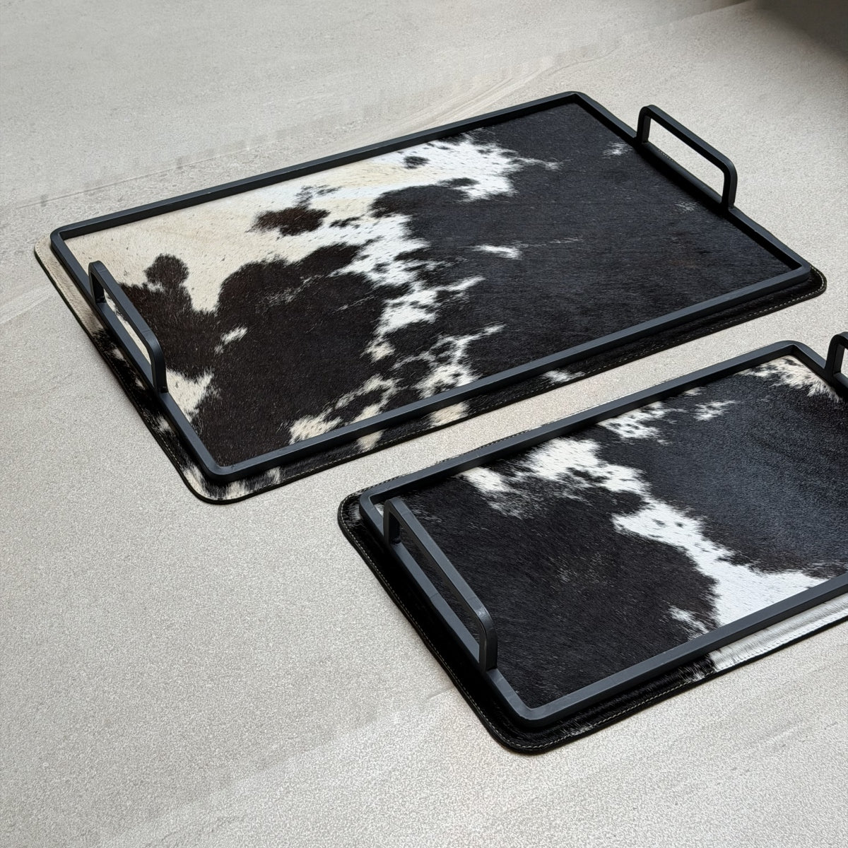 Set de charolas cowhide - 296, vista cerca 2. Piel natural negro y blanco y herrería negra.