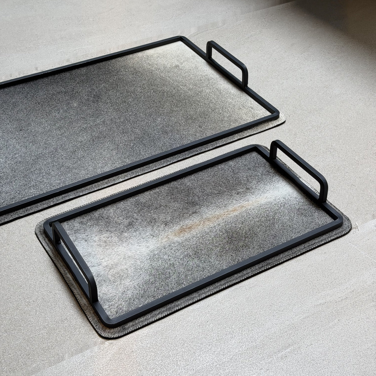 Set de charolas cowhide - 300, vista cerca 2. Piel natural gris plateado y herrería negra.