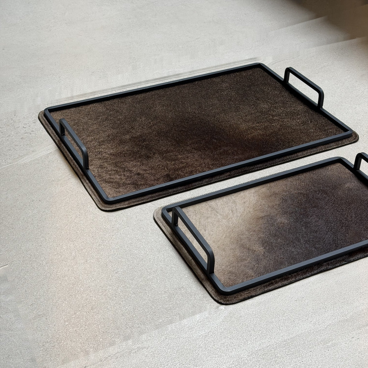 Set de charolas cowhide - 303, vista cerca 3. Piel natural café con matices claros y herrería negra.