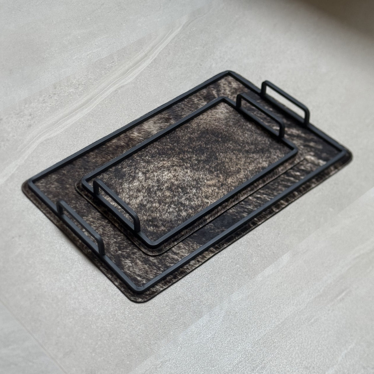 Set de charolas cowhide - 307, vista lejos 2. Piel natural café jaspeado y herrería negra.