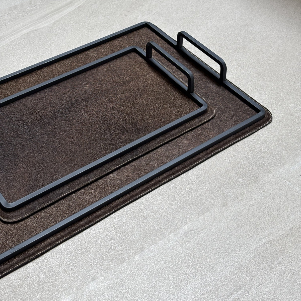 Set de charolas cowhide - 309, vista cerca 2. Piel natural café y herrería negra.