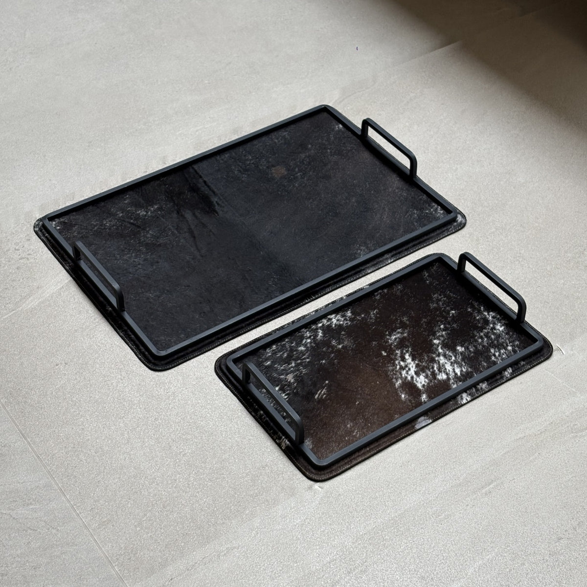 Set de charolas cowhide - 310, vista lejos. Piel natural negro y café con blanco y herrería negra.